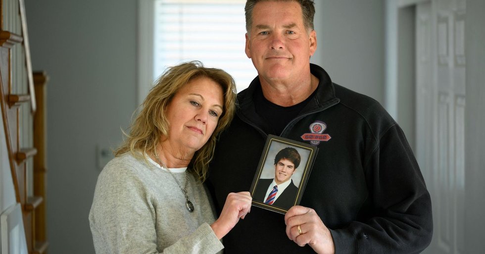 Kristi and Bill Anderson hold a photo of their late son, Jake Anderson, inside their home. (Aaron Lavinsky/The Minnesota Star Tribune)