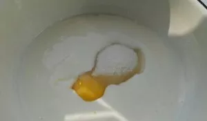 Kambario temperatūros kefyrą sumaišyti su cukrumi, kiaušiniu ir druska.